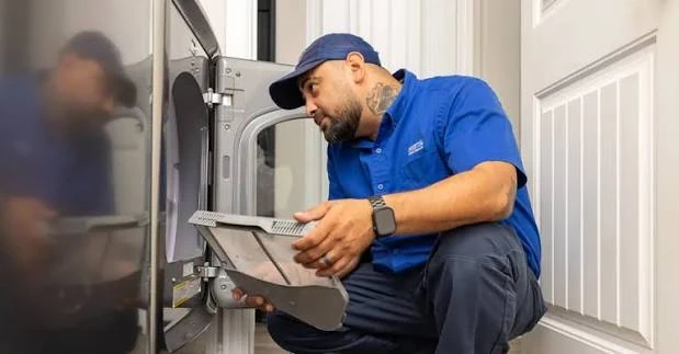 Technician inspecting a dryer lint filter